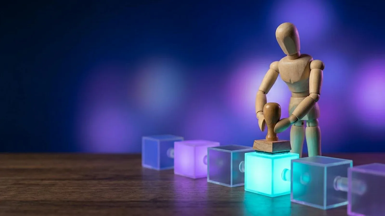 Blockchain para empresas: muñeco de madera sella con un tampón un bloque de una cadena de cubos de luz enlazados.